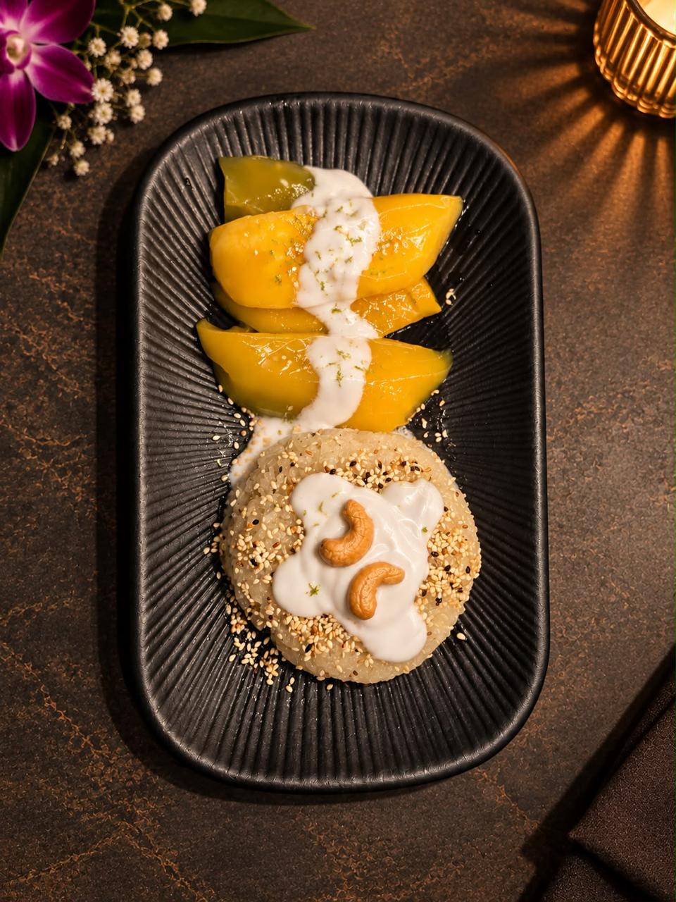 Mango Sticky Reis mit Kokosmilch auf einem schwarzen Teller